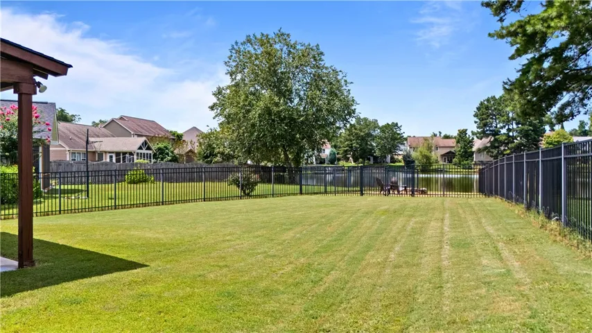 Nice-sized back yard with attractive aluminum fencing and a fire pit
