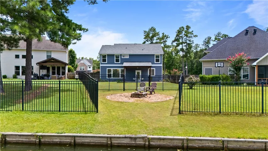 View of the back yard and house from the pond. There is also a fire pit to enjoy.
