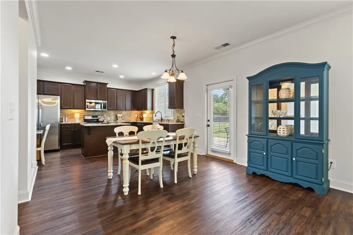 View of second dining area, kitchen, and door leading to the covered patio