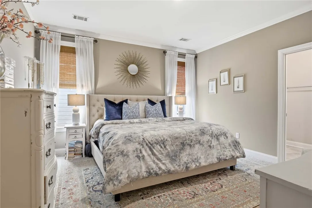 A well-lit bedroom with crown molding and recessed lighting, offering comfort and style.