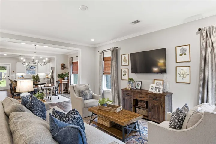 An inviting open-concept living area seamlessly connects to a dining space and kitchen, ideal for entertaining.