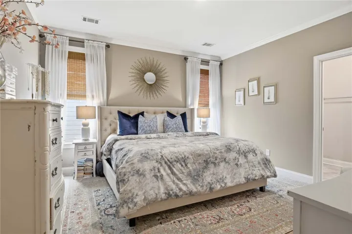 A well-lit bedroom with crown molding and recessed lighting, offering comfort and style.