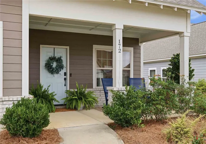 A welcoming front porch with well-maintained landscaping offers a charming entry to this residence.