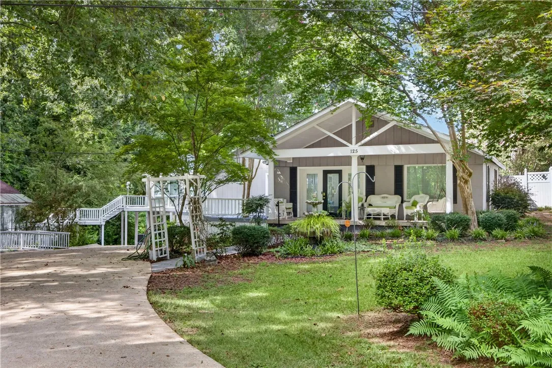 A welcoming front facade with a covered porch and mature landscaping offers serene outdoor living.