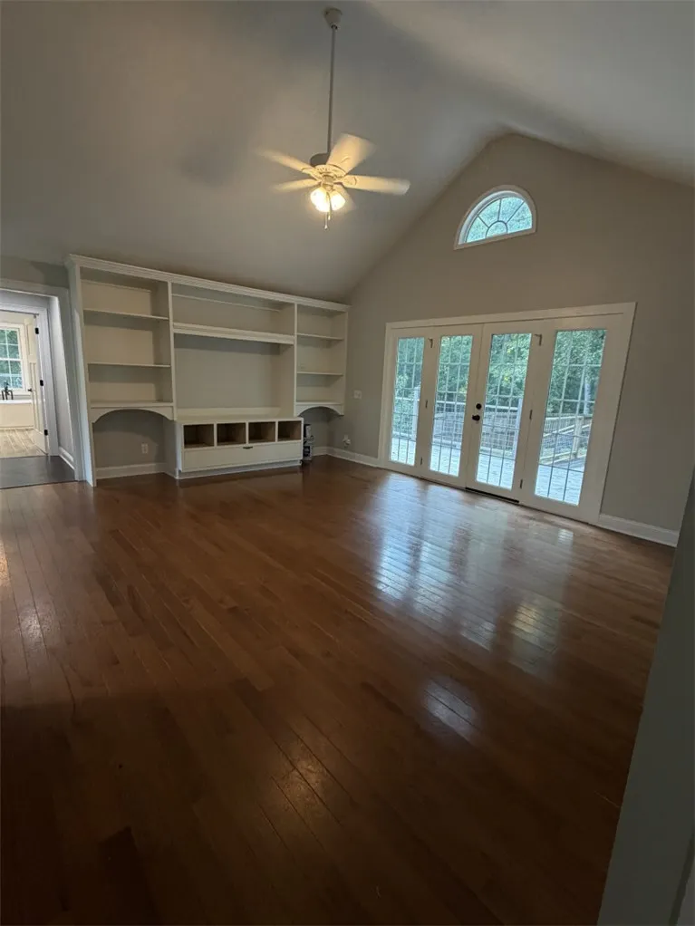 Built-in shelving and gleaming hardwood floors define this naturally illuminated living space.
