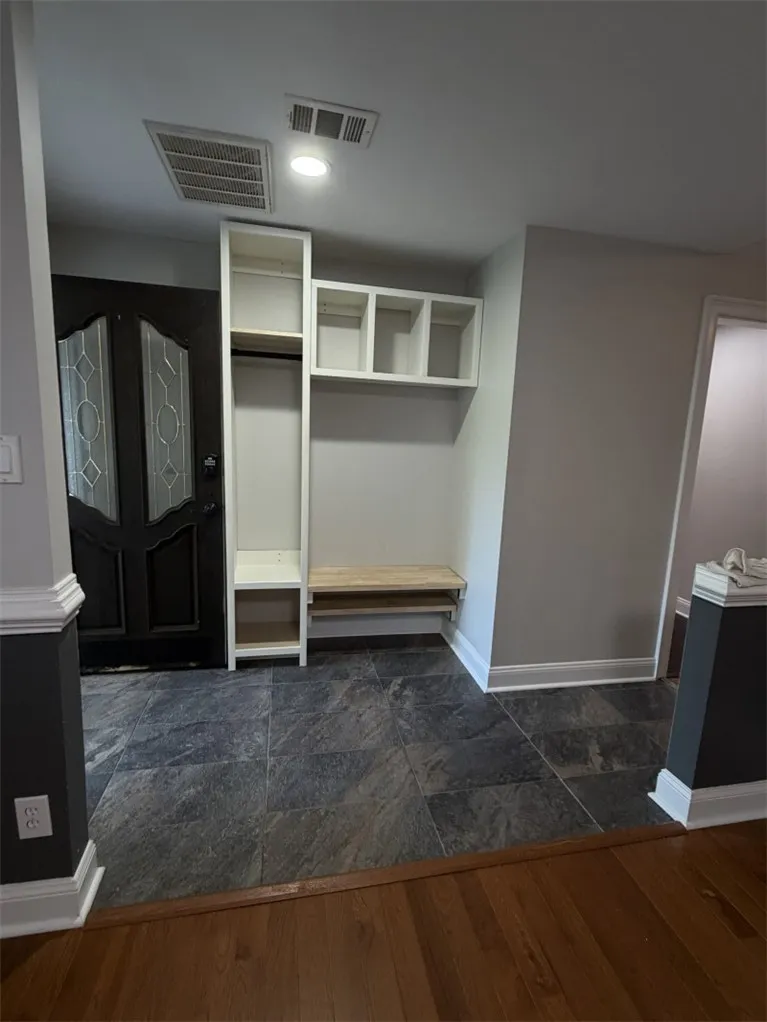 A welcoming entryway offers practical built-in storage and convenient seating.