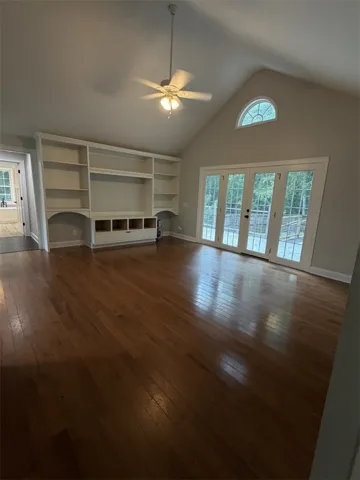 Built-in shelving and gleaming hardwood floors define this naturally illuminated living space.