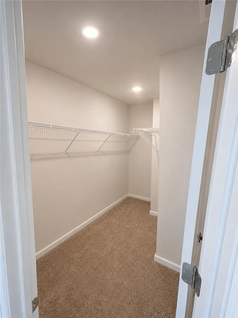 A well-lit, generous closet provides ample storage solutions.