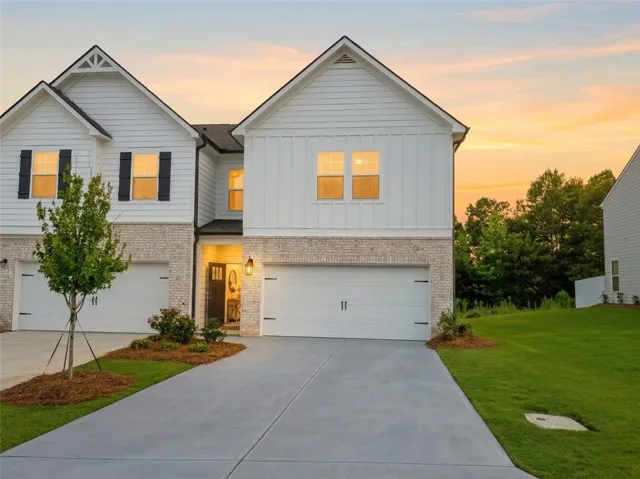 A striking modern facade with brick accents and inviting porch lighting welcomes you home.