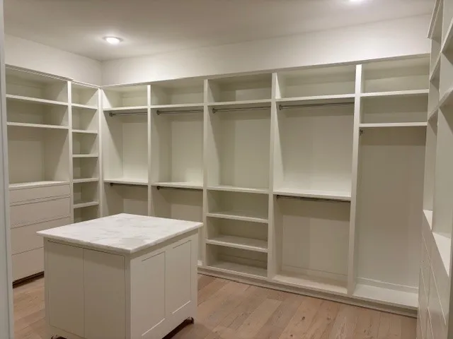 Custom built-in shelving and a center island define this spacious wardrobe area.