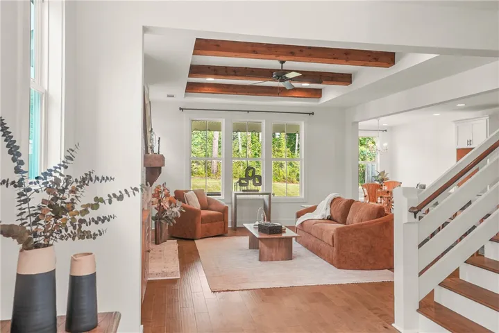 Stunning open concept living room complete with fireplace and accent beams