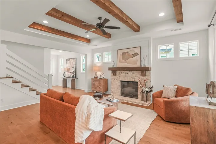 Stunning open concept living room complete with fireplace and accent beams