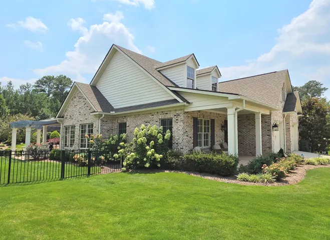 Side view shows off the front and back porches & fenced in yard