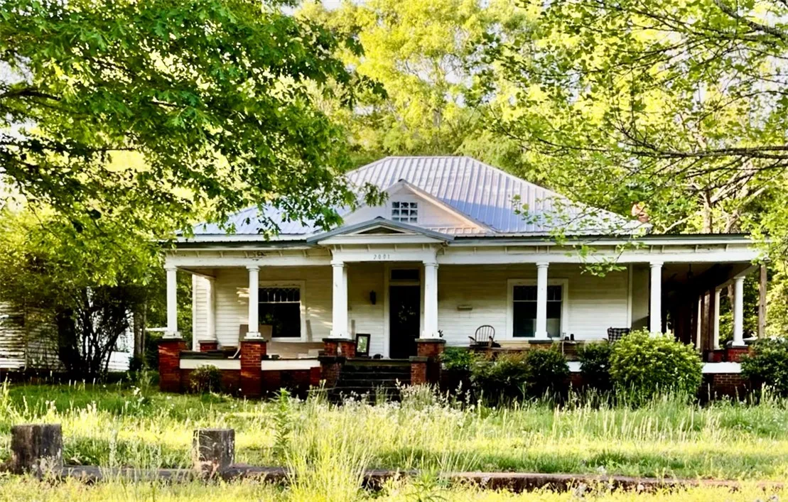 This is an older photo of the house before the front and side porches were removed.