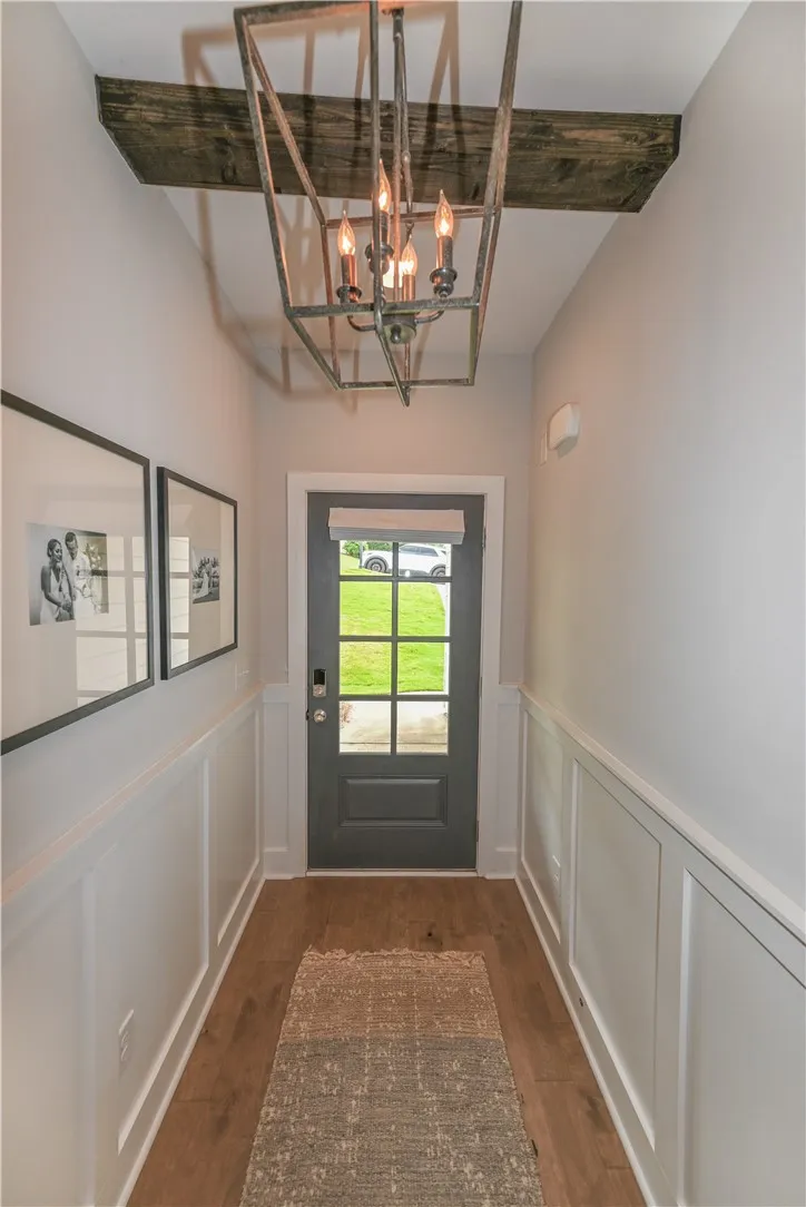 Foyer features wainscoting and wood beam detail