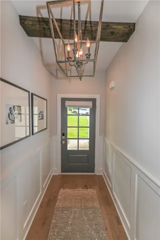 Foyer features wainscoting and wood beam detail