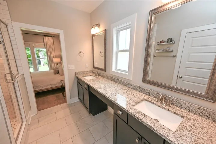 Vanity features built-in dressing table and window flanked by dual sinks