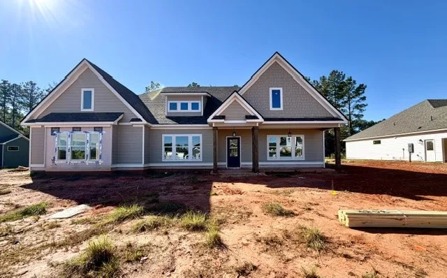Distinctive architectural gables and crisp siding define this newly constructed home under a clear sky.