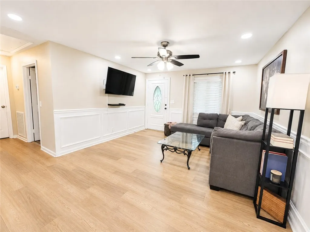 Bright vinyl plank flooring flows through this inviting living room, complemented by detailed wainscoting.