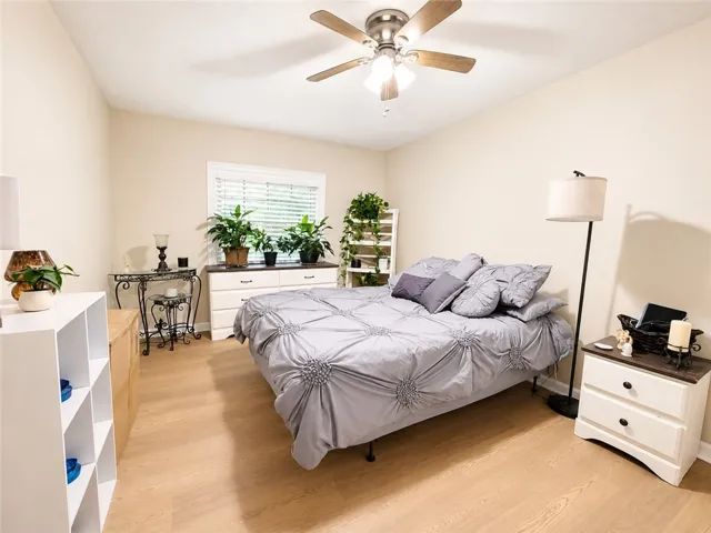 Comfortable bedroom with warm tones, sleek flooring, and ample natural light.