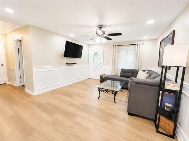 Bright vinyl plank flooring flows through this inviting living room, complemented by detailed wainscoting.