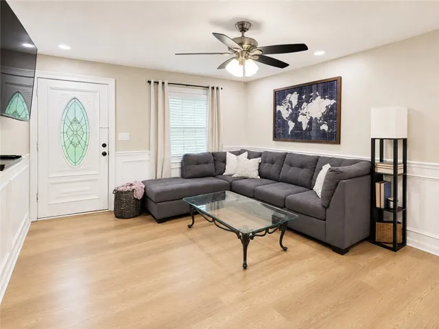 Natural wood flooring complements the welcoming living area, perfect for daily relaxation and gatherings.