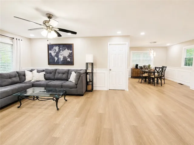 A generously proportioned living space flows seamlessly into the dining area, featuring attractive wood flooring throughout.