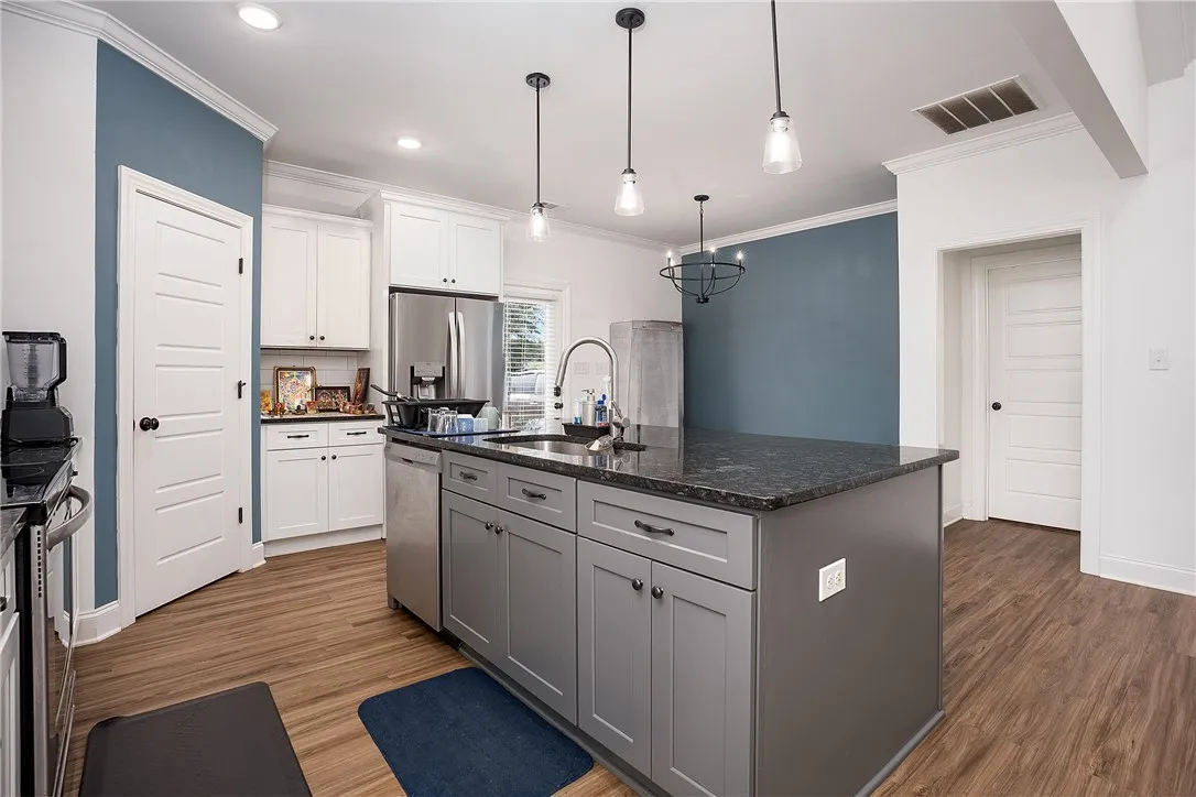 A contemporary kitchen features an inviting island with a deep sink and pendant lighting.