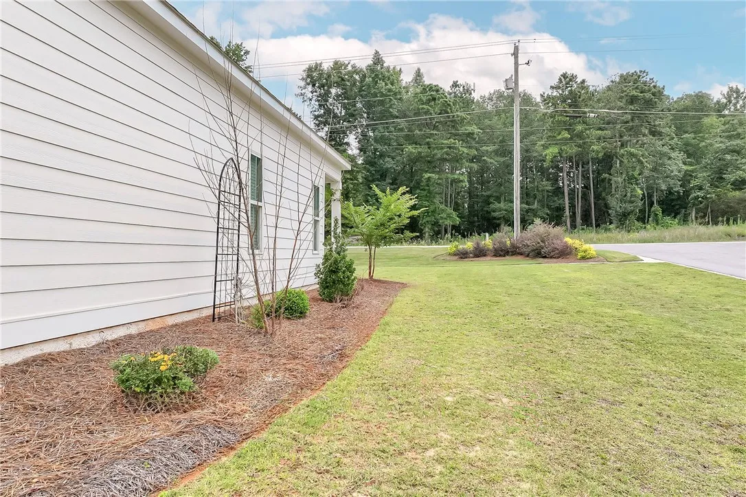 A well-maintained side yard with natural landscaping complements this residence.