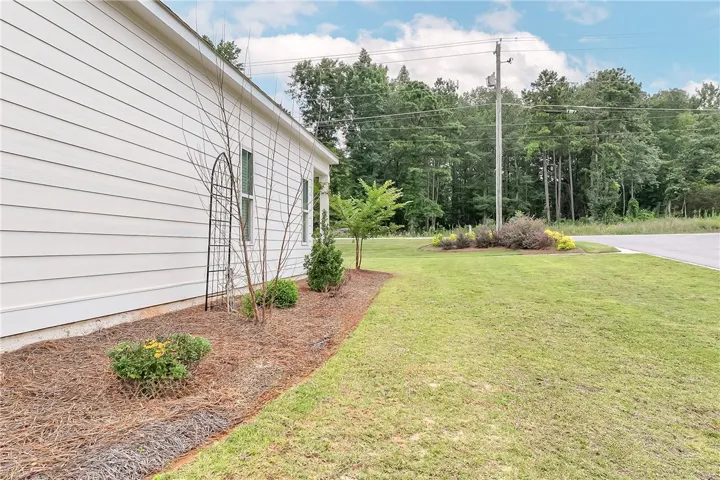 A well-maintained side yard with natural landscaping complements this residence.