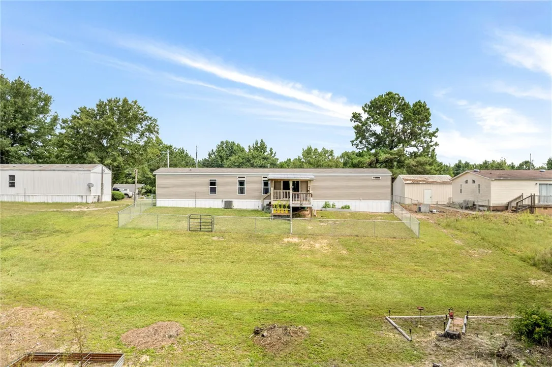 A spacious lot featuring a single-story manufactured home with a relaxing back porch and deck.