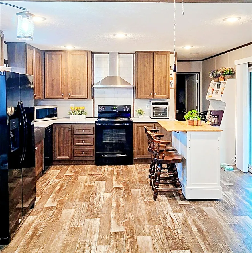 Warm wood cabinetry paired with textured wood-look flooring creates an inviting and functional culinary space.