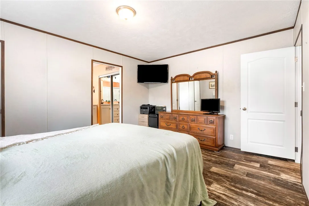 Rich wood-look flooring and molding define this comfortable bedroom space.