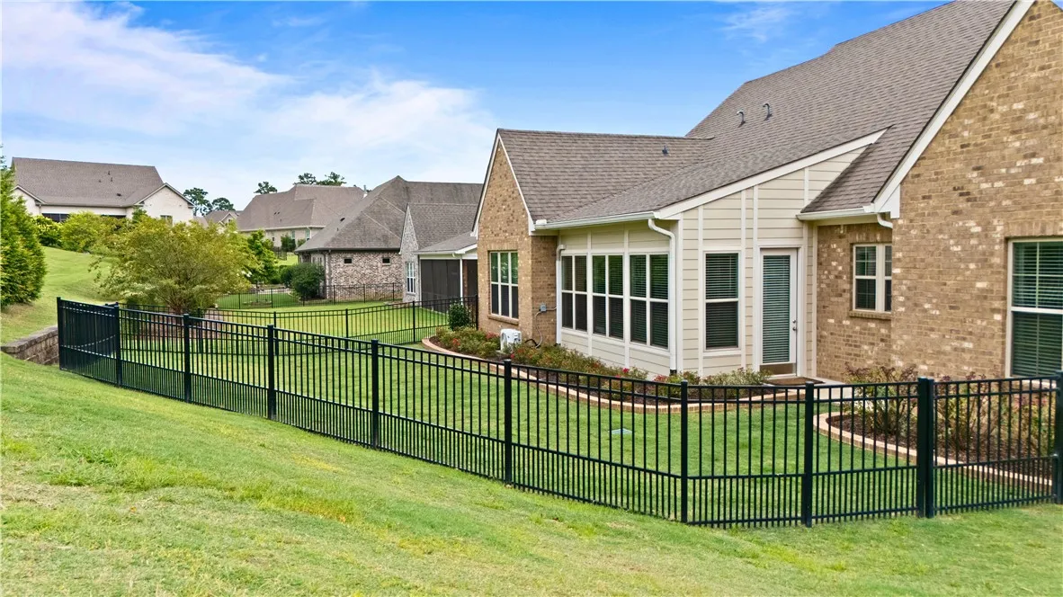 Fenced back yard. The fence is black aluminum with a gate.