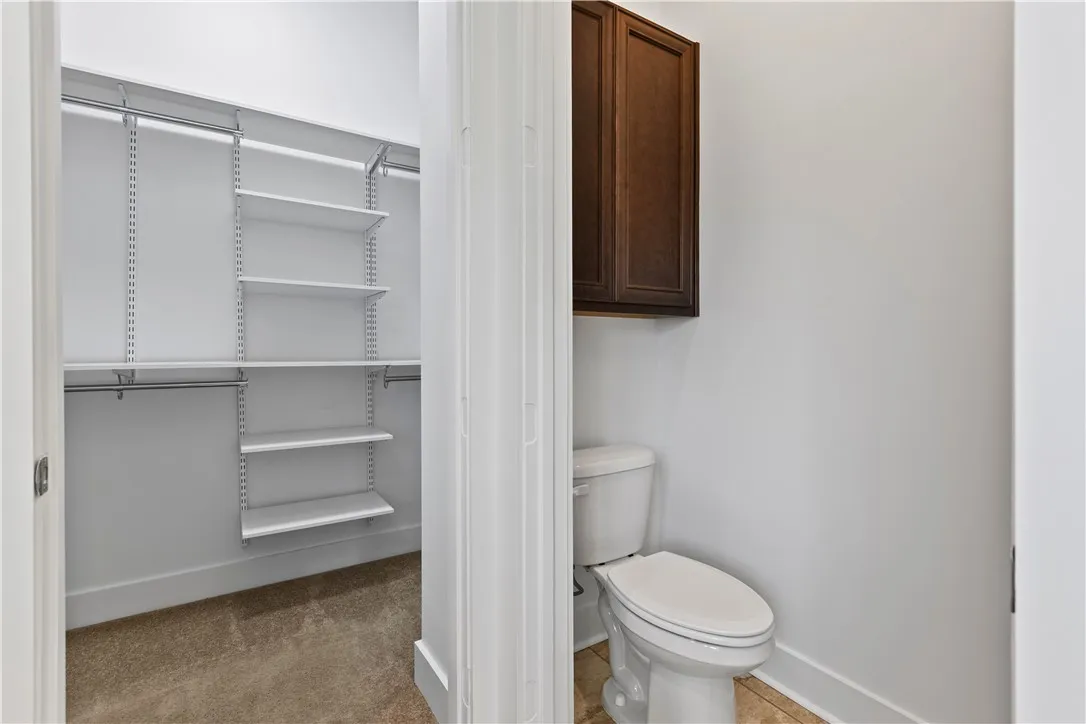 Water closet and the walk-in closet offers shelving for nice organization, full length mirror