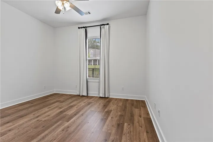 Bedroom 3 on the left side of the home with custom drapes that can convey with the home or be removed (ensuite)