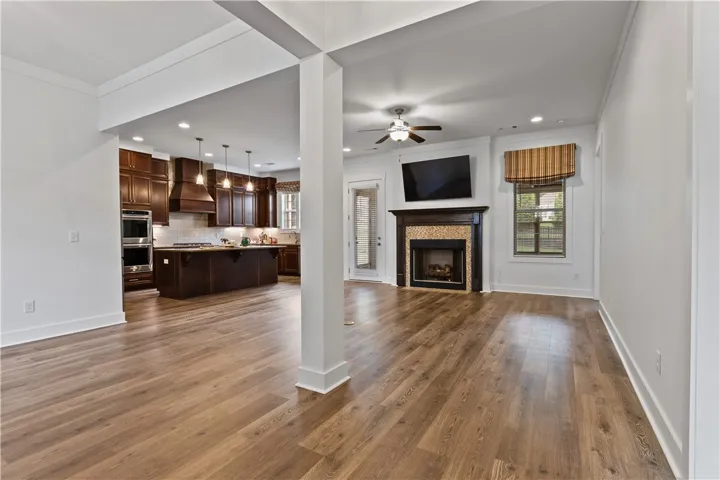 An open-concept interior offers a fireplace, LVP wood floors, and recessed lighting in a flowing layout.