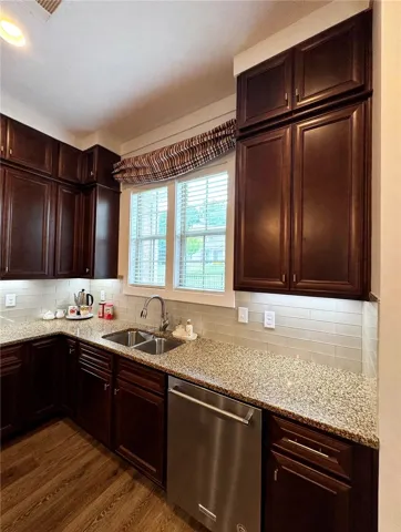 Sink area and stainless steel dishwasher. Custom valance can convey with the home or be removed.