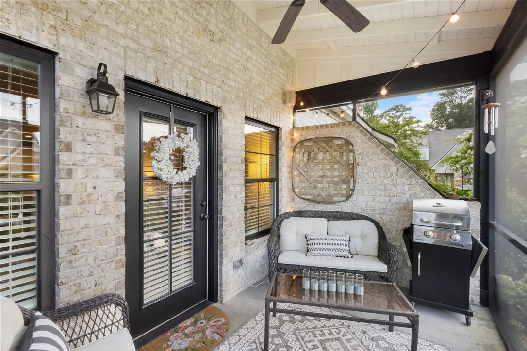 Brick walls and a screened enclosure define this comfortable covered patio space.