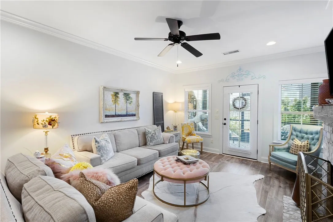 Rich wood tone flooring and classic crown molding elevate this open, welcoming living space.