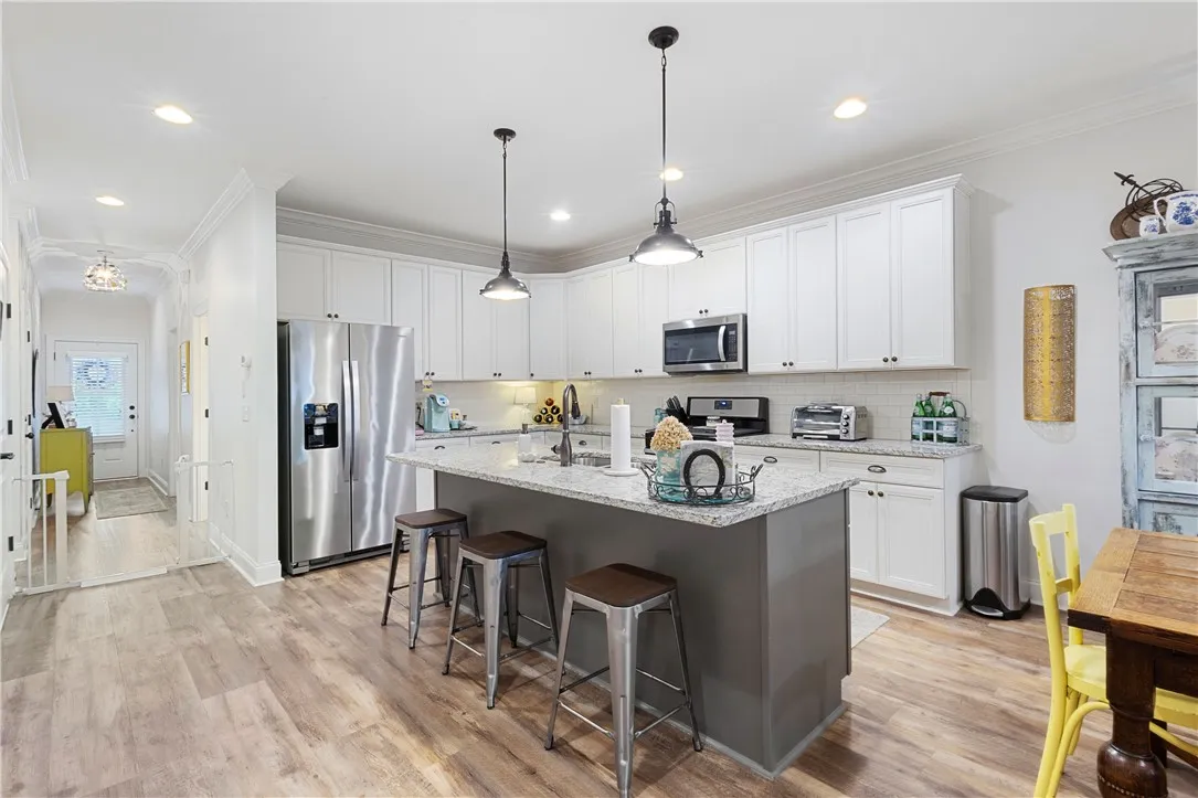 Gleaming stone countertops and a spacious central island anchor this modern culinary workspace.