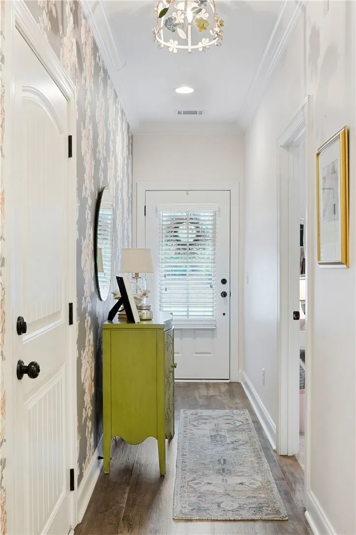 Elegant crown molding and warm wood-look floors guide guests through this inviting entryway.