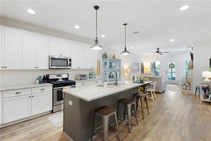 Polished granite countertops anchor this kitchen, opening directly to a sunlit living space.