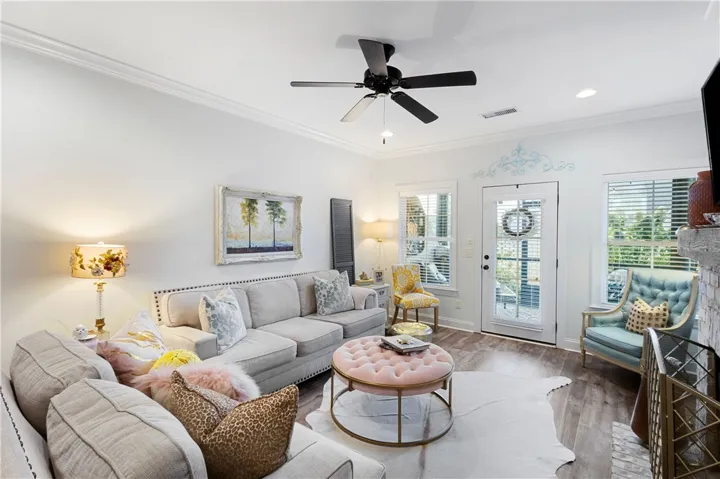 Rich wood tone flooring and classic crown molding elevate this open, welcoming living space.