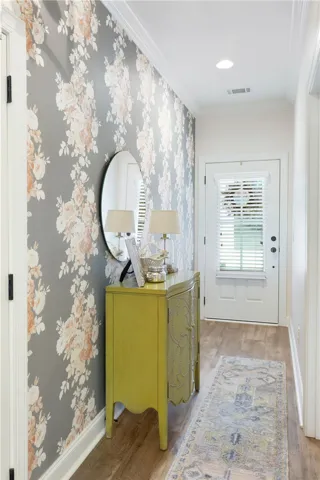Crown molding and hardwood flooring elevate this welcoming entrance hallway.