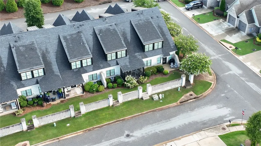 Multi-level townhome architecture showcases distinctive gabled rooflines along a manicured neighborhood street.