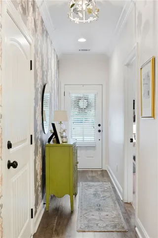 Elegant crown molding and warm wood-look floors guide guests through this inviting entryway.