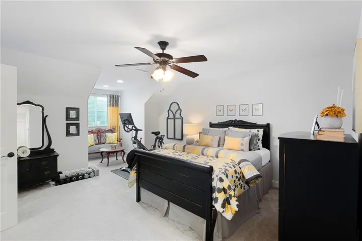 Plush carpeting anchors this spacious bedroom featuring a recessed sitting alcove with natural light.