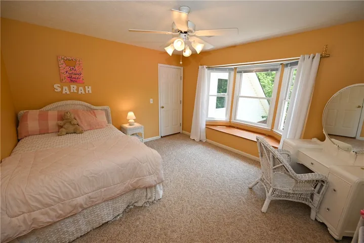 Bedroom 4 (upstairs) with walk-in closet, window seat with storage, & adjacent walk-in attic space.