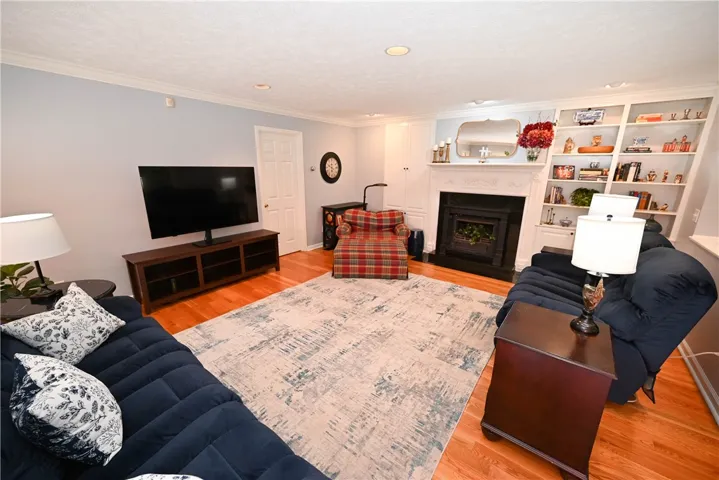 Great room's cozy fireplace is flanked by built-ins. Door on left leads to the primary suite's private study.